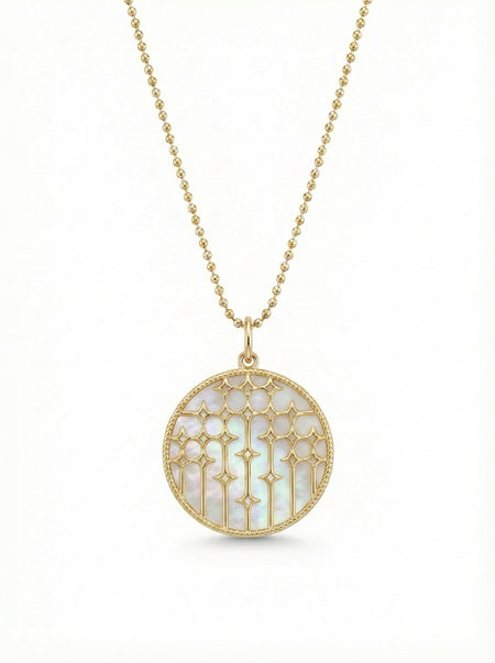 14Kt gold and mother of pearl disc necklace featuring diamonds in a starburst pattern.