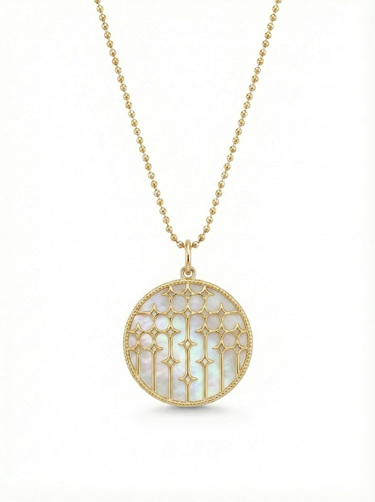 14Kt gold and mother of pearl disc necklace featuring diamonds in a starburst pattern.